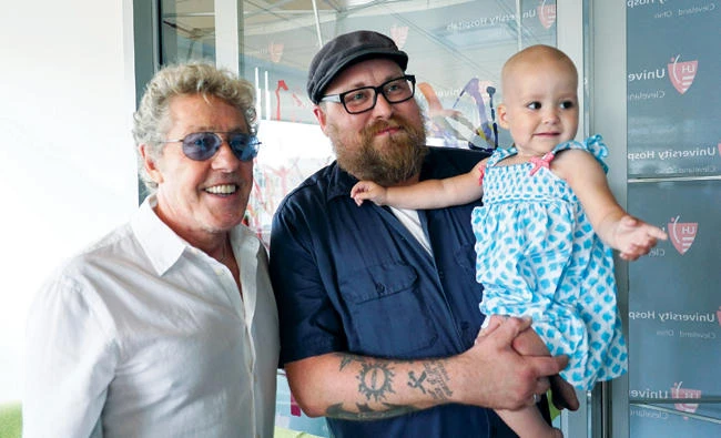 Roger Daltrey, lead singer for the English rock band The Who, left, poses with Adam Kirk and his daughter Sawyer McGhee, a cancer patient, in Cleveland. (AP)