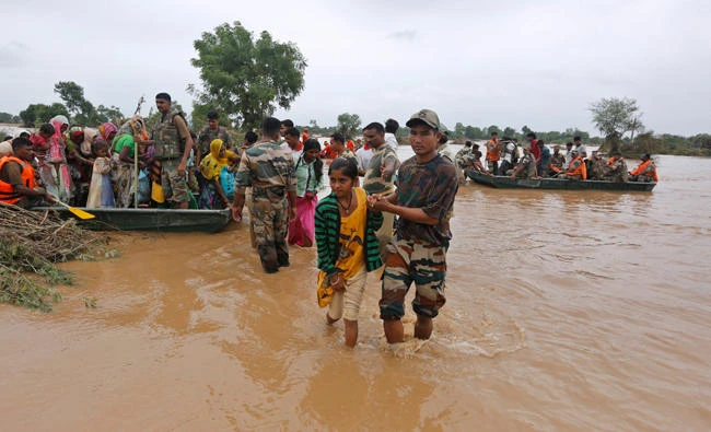 India army soldiers rescue flood affected villagers near Thara in Banaskantha district on Wednesday, Gujarat, India, . (AP Photo/Ajit Solanki)