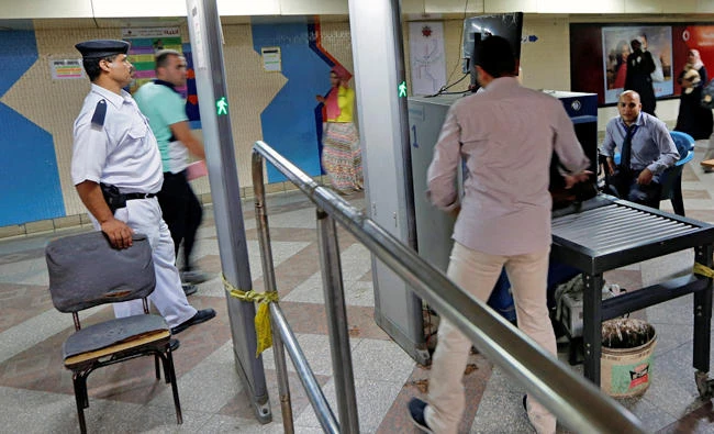 Egyptian policemen check the bags of passengers at a security check point in Al Shohadaa "Martyrs" metro station, formerly know as "Mubarak", in Cairo, Egypt, on Monday. Egypt has been reeling from terrorist attacks in the past months. (REUTERS/Amr Abdallah Dalsh)