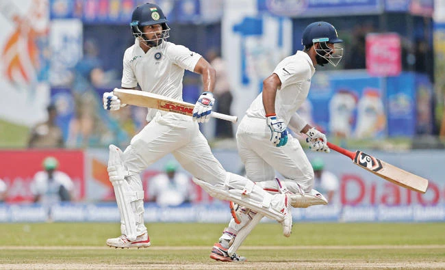 India's cricketers Shikhar Dhawan, left, and Cheteshwar Pujara run between wickets during day one of
the first Test against Sri Lanka on Wednesday. (Reuters)