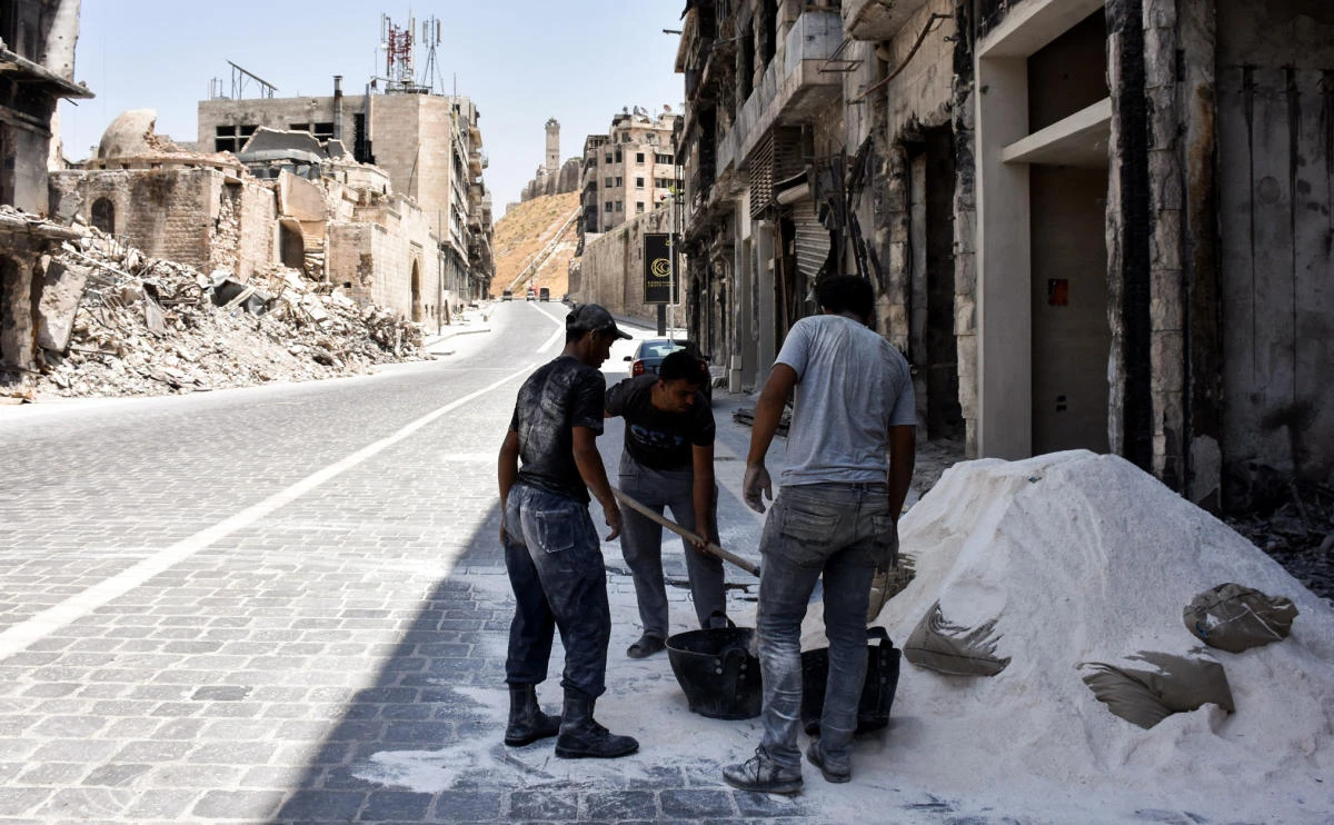 Syrian construction workers rebuild a damaged store in Khan al-Wazir market in Aleppo's old city on July 22, 2017, which was recaptured by government forces in December 2016. (AFP)