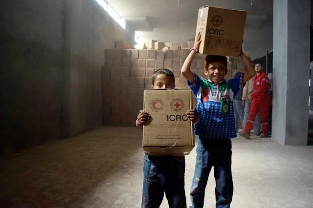 Syrian children carry aid parcels on May 2, 2016. (AFP)