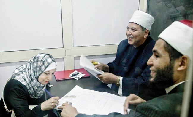 Al-Azhar religious leaders answer a woman's question inside a Fatwa Kiosk at the Al Shohada'a metro station in Cairo, Egypt. (AP)