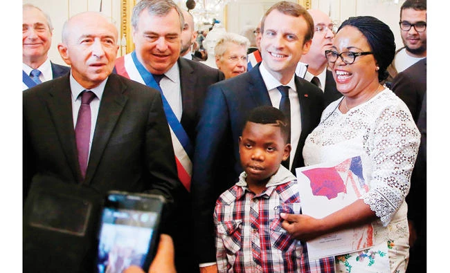 French Interior Minister Gerard Collomb and French President Emmanuel Macron pose with Aurelie Dion as she becomes a French citizen during a ceremony in Orleans, central France, on Thursday. (AFP)