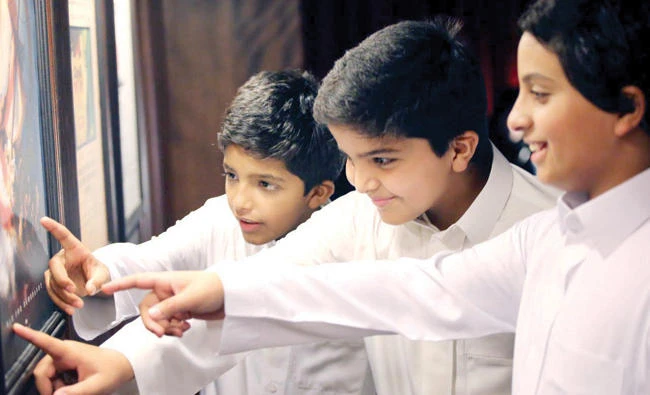 Naif, Sultan and Fahd look at posters to figure out the clues and solve the mystery. (AN photo by Essam Al-Ghalib)