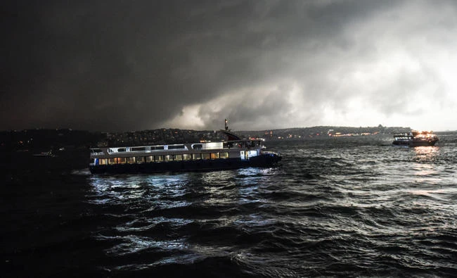 Storm clouds gather overhead as a ferry arrives at the port of Besiktas in Istanbul on Thursday. (AFP / BULENT KILIC)