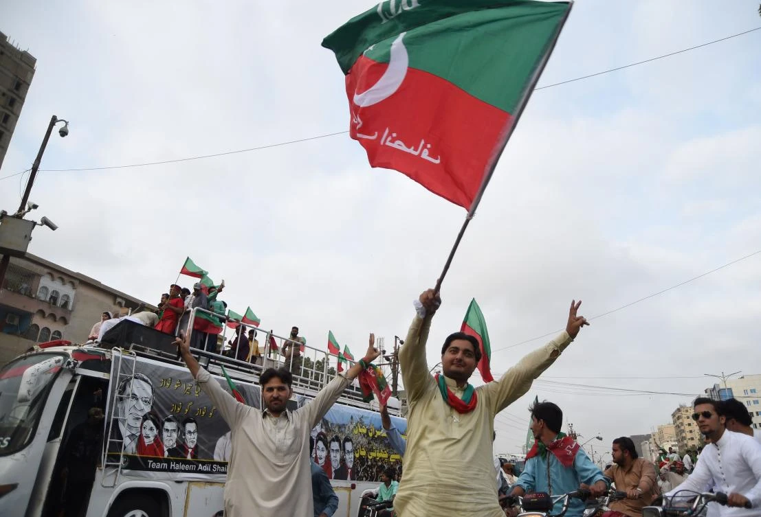 Supporters of opposition leader Imran Khan's Pakistan Tehreek-i-Insaf (PTI) march as they celebrate on a street after the Supreme Court decison against Pakistan's Prime Minister Nawaz Sharif near Khan's residence in Karachi on July 28, 2017. Pakistan's Supreme Court on July 28 disqualified Prime Minister Nawaz Sharif from public office over long-running corruption allegations, a decision that ousts him from the premiership for the third time in a chequered political career. / AFP / ASIF HASSAN