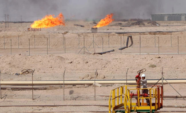 A worker adjusts a valve of an oil pipe in Zubair oilfield in Basra, Iraq, in this July 20, 2017 photo. (REUTERS)