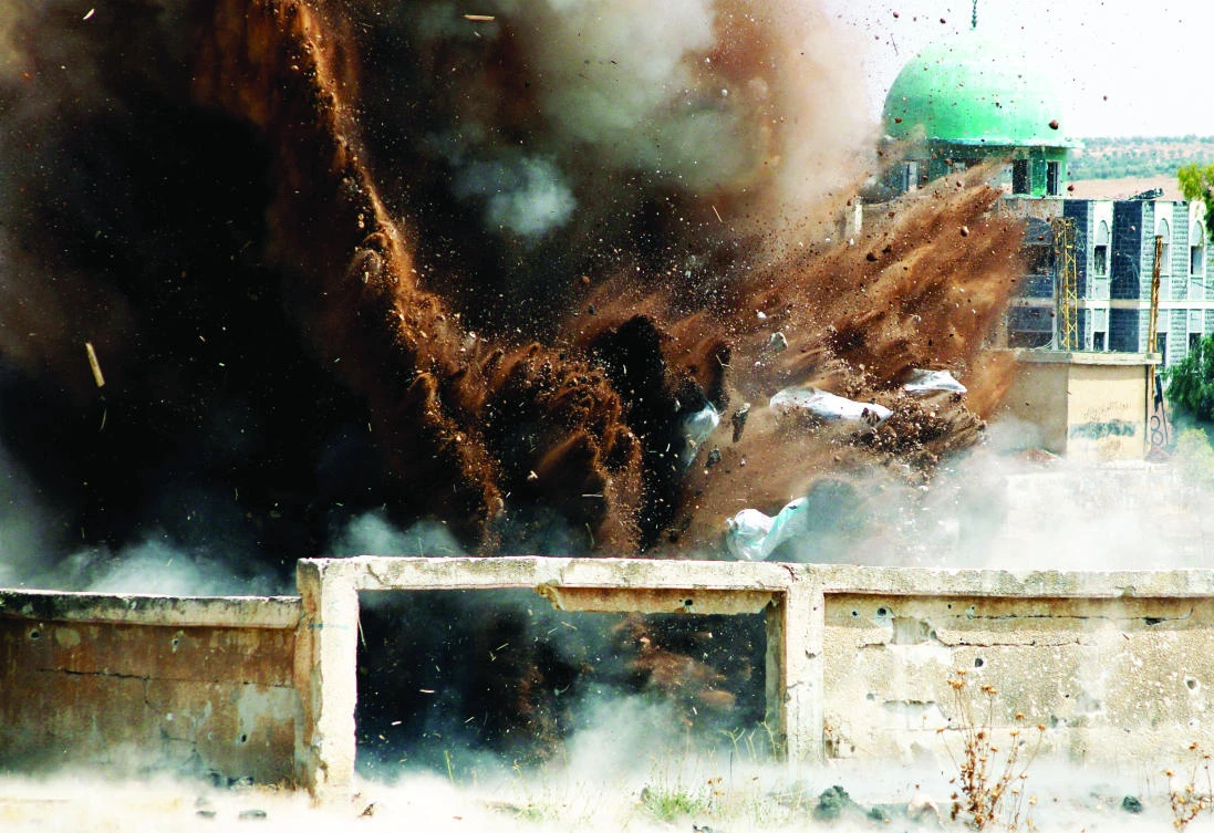 Civil defense members safely detonate cluster bombs in Deraa, Syria, on Wednesday. (Reuters)