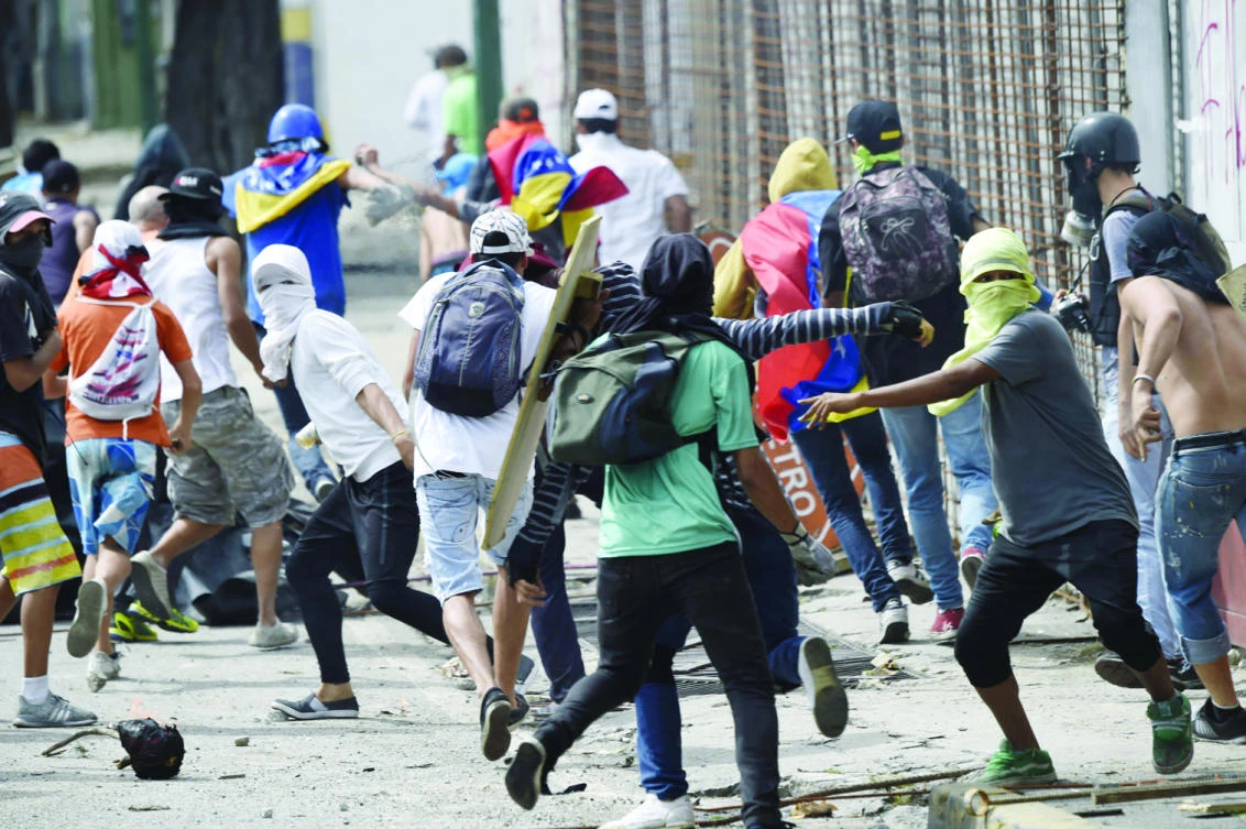 Anti-government activists clash with the riot police in Caracas on Thursday on the second day of a 48-hour general strike
called by the opposition. (AFP)