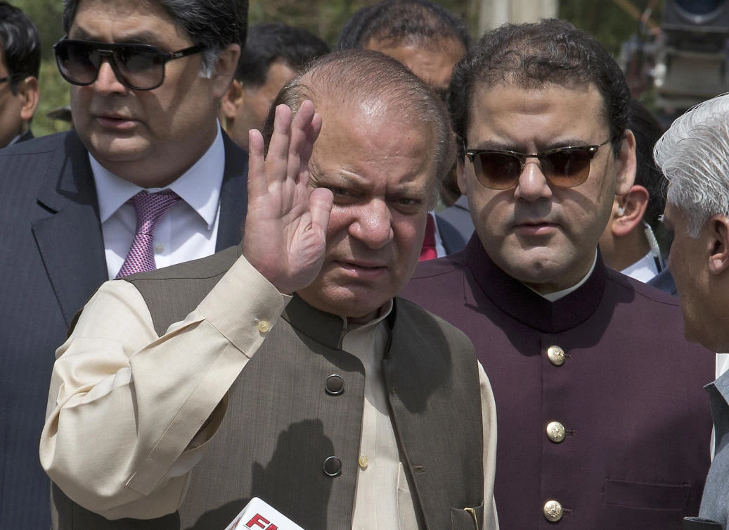 In this Thursday, June 15, 2017, photo, Pakistani Prime Minister Nawaz Sharif waves with his son Hussain Nawaz, right, outside the premises of the Joint Investigation Team, in Islamabad, Pakistan. Pakistan's Supreme Court in a unanimous decision has asked the country's anti-corruption body to file corruption charges against Prime Minister Nawaz Sharif, his two sons and daughter for concealing their assets. (AP)