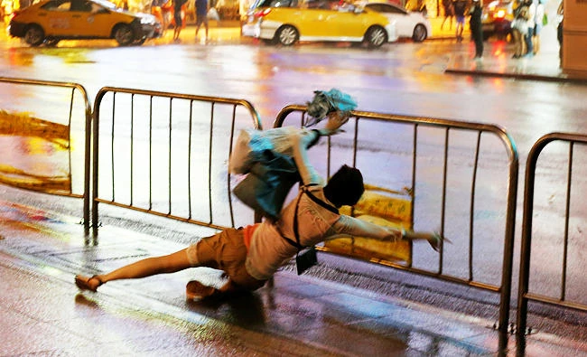 A woman falls as Typhoon Nesat hits Taipei, Taiwan on Saturday. (REUTERS)