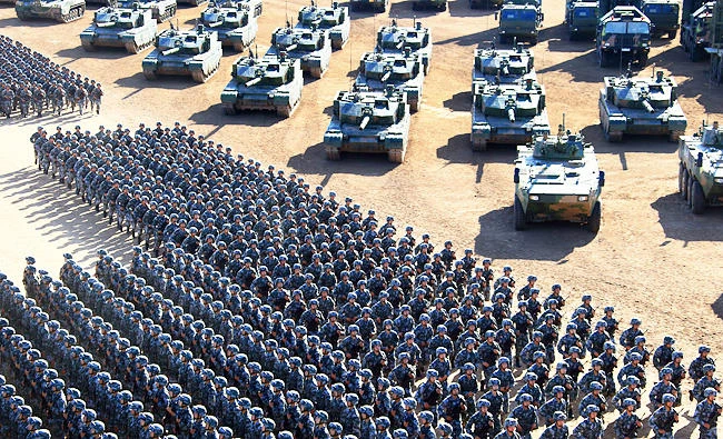 In this photo released by China's Xinhua News Agency, Chinese People's Liberation Army (PLA) troops march past military vehicles on Sunday as they arrive for a military parade to commemorate the 90th anniversary of the founding of the PLA on Aug. 1 at Zhurihe training base in north China's Inner Mongolia Autonomous Region. (AP)
