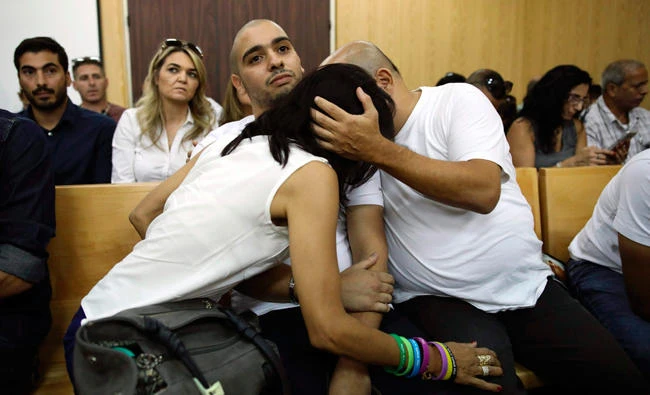 Elor Azaria, center, is embraced by his parents during a hearing at a military court in Tel Aviv on Sunday. (AP)