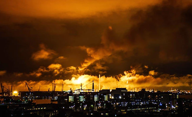 A photo taken at night on July 29, 2017 shows flames and smoke rising above the Shell refinery in Rotterdam. (AFP)