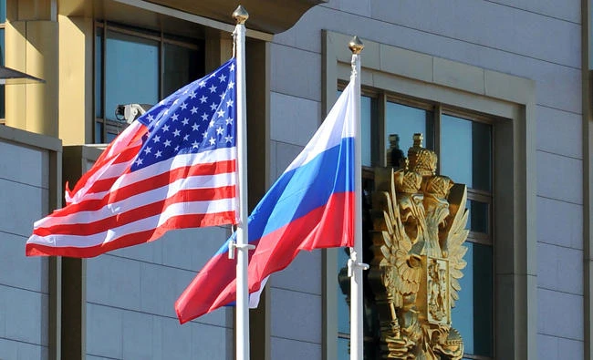This photo taken on May 7, 2013 shows Russian and the US flags running up as the US Secretary of State arrives at Moscow Vnukovo Airport. Russian President Vladimir Putin said on July 30, 2017, that 755 US diplomats must leave his country, after Moscow announced it would expel American staff in retaliation for tough new sanctions from Washington. (AFP / Mladen Antonov)