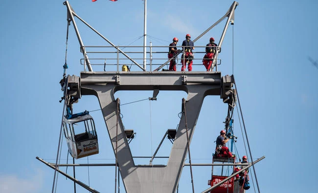 A gondola of the Cologne cable car, which crosses the Rhine, wedged itself on a ropeway support over the Rhine in Cologne, western Germany, on Sunday. (AFP)