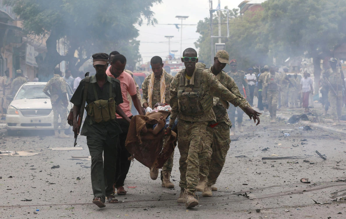 Somali military officers evacuate an injured man from the scene of an explosion in Maka al Mukaram road in Mogadishu, Somalia, on Sunday. (REUTERS/Feisal Omar)
