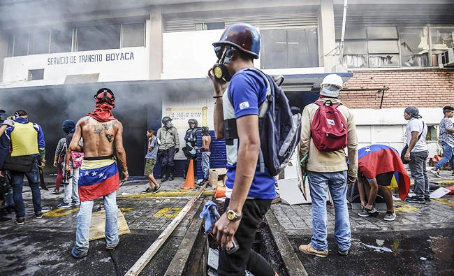 Anti-government activists attack and set on fire a National Traffic Police station during a protest against the election of a Constituent Assembly proposed by Venezuelan President Nicolas Maduro, in Caracas on Sunday. (AFP)