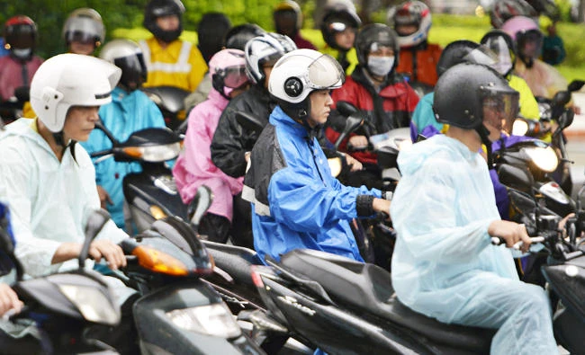 Motorcyclists clad in rainjackets and ponchos ride to work in Taipei as tropical storm Haitang hits Taiwan on Monday. (AFP)