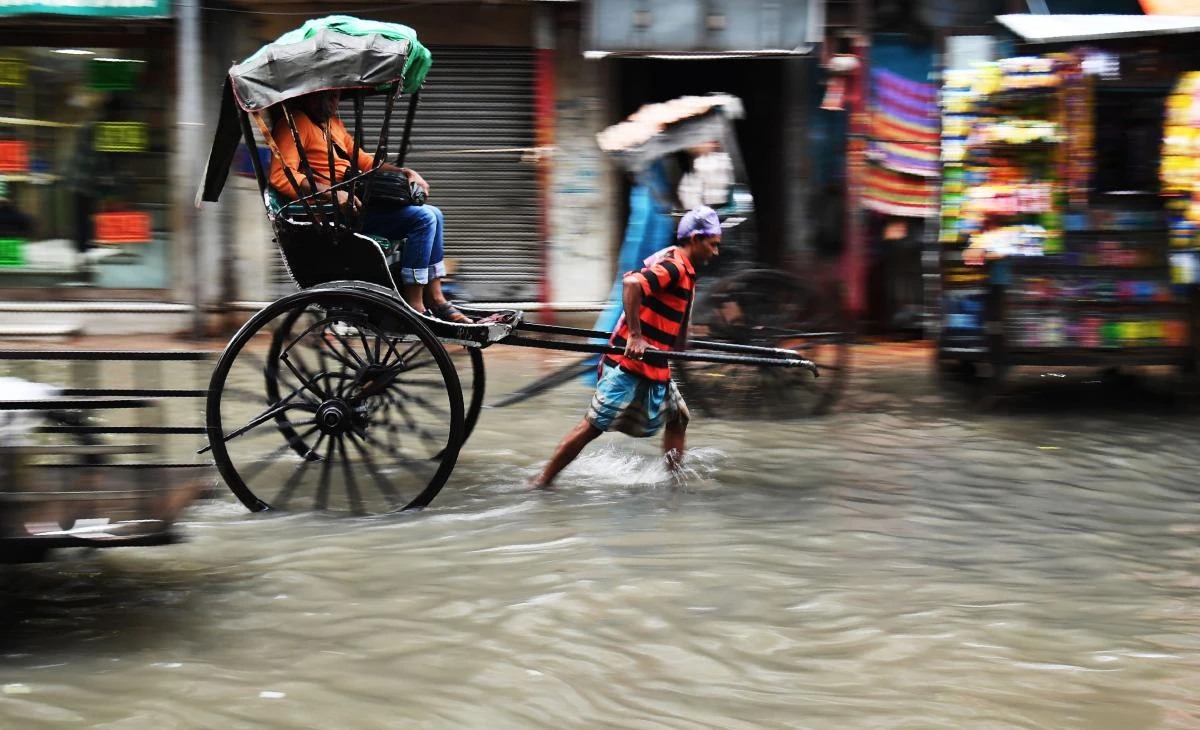 An Indian hand-puller-rikshaw wades through a water logged street in Kolkata on July 24, 2017. (AFP)