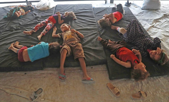 Syrian children who fled with their families the battle between U.S.-backed Syrian Democratic Forces (SDF) and Daesh militants from Raqqa city, lie on mattresses inside a transfer tent upon their arrival at a refugee camp, in Ain Issa town, northeast Syria, on July 24, 2017. (AP Photo/Hussein Malla)