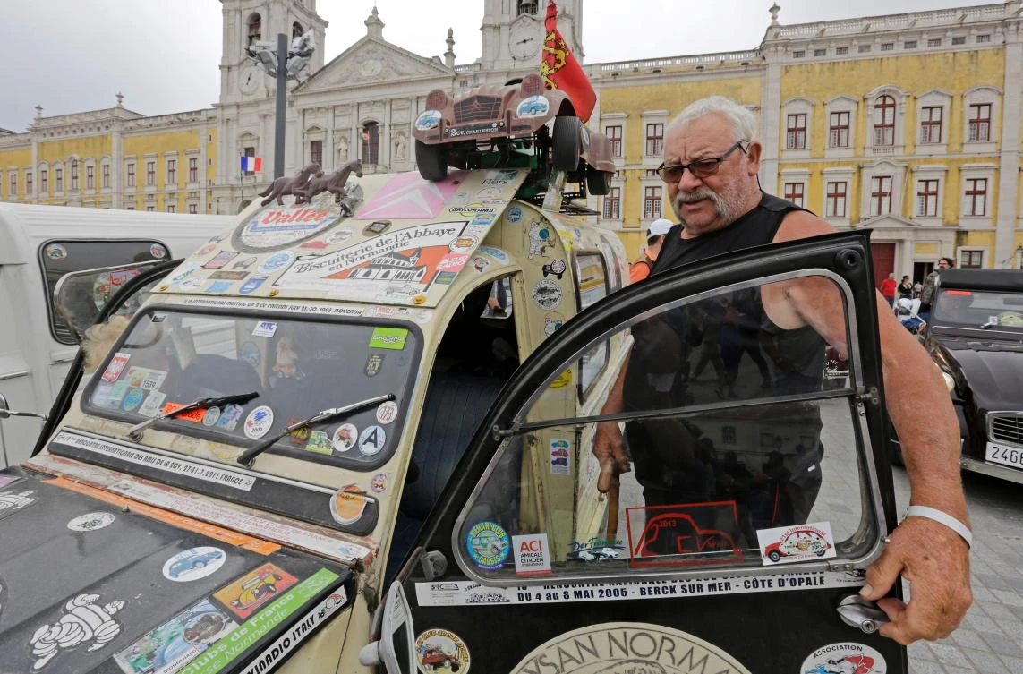 Participant gets out of his car on the parking area in Mafra after the parade of Citroen classic cars 2CV during the World 2017 2CV Meeting July 30, 2017. The event is held between the 26th and the 31st of July 2017, 30 years after Portugal hosted the seventh 2CV World Meeting in 1987, and will include activities ranging from an open air fair, a competition to disassemble and reassemble, an "elegance" contest for original and modofied 2CV's, a chimes concert, to a short term 2CV museum hosted by the Marfa national palace featuring vehicles from the Citroen Heritage collection purposely brought from Paris. / AFP / JOSE MANUEL RIBEIRO