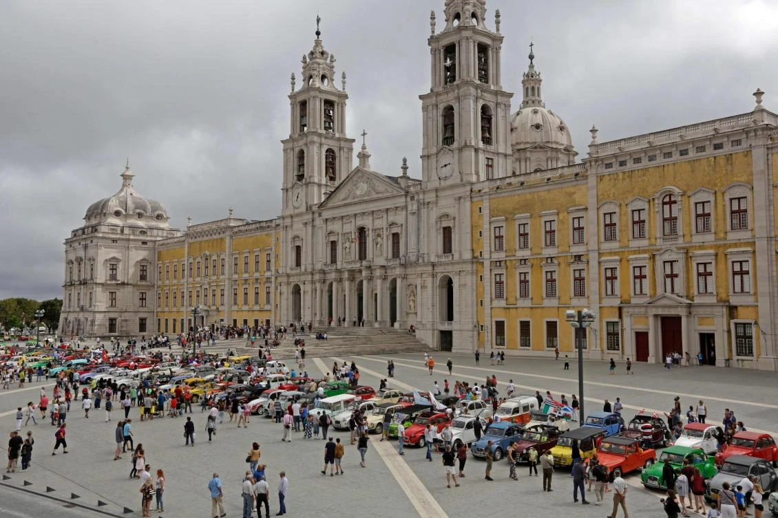 Visitors queue to look at the parked cars in Mafra after the parade of Citroen classic cars 2CV during the World 2017 2CV Meeting July 30, 2017. The event is held between the 26th and the 31st of July 2017, 30 years after Portugal hosted the seventh 2CV World Meeting in 1987, and will include activities ranging from an open air fair, a competition to disassemble and reassemble, an "elegance" contest for original and modofied 2CV's, a chimes concert, to a short term 2CV museum hosted by the Marfa national palace featuring vehicles from the Citroen Heritage collection purposely brought from Paris. / AFP / JOSE MANUEL RIBEIRO
