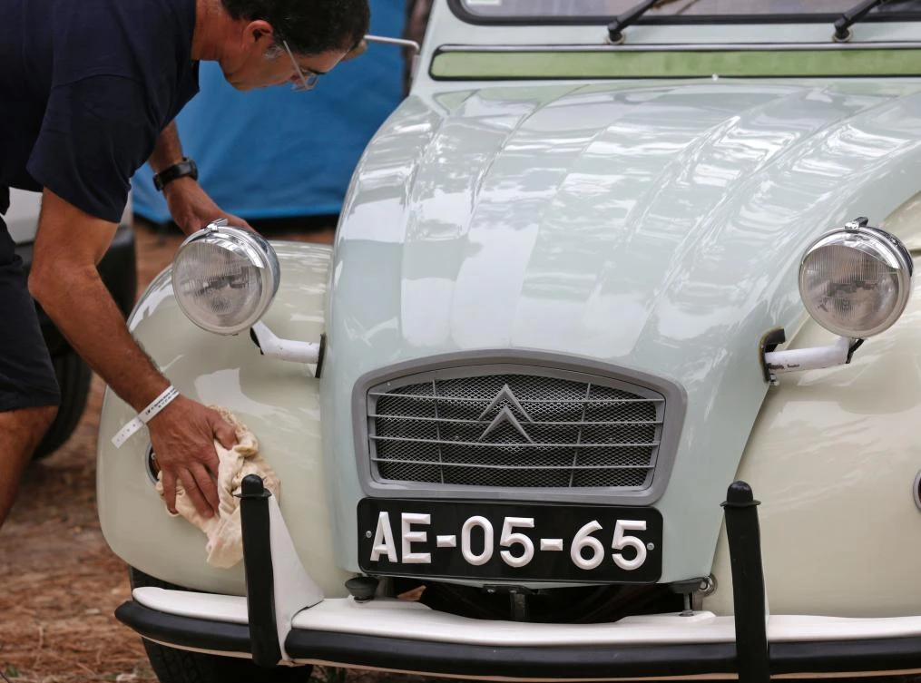 A participant shines his Citroen classic car 2CV before the parade at Ericeira village during the World 2017 2CV Meeting July 30, 2017. The event is held between the 26th and the 31st of July 2017, 30 years after Portugal hosted the seventh 2CV World Meeting in 1987, and will include activities ranging from an open air fair, a competition to disassemble and reassemble, an "elegance" contest for original and modofied 2CV's, a chimes concert, to a short term 2CV museum hosted by the Marfa national palace featuring vehicles from the Citroen Heritage collection purposely brought from Paris. / AFP / JOSE MANUEL RIBEIRO
