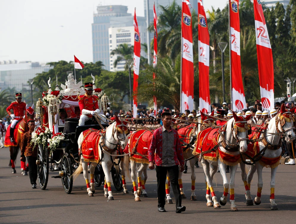 A horse-drawn carriage carries the national flag from the National Monument to the Presidential Palace for Independence Day celebrations in Jakarta, Indonesia August 17, 2017. REUTERS/Darren Whiteside