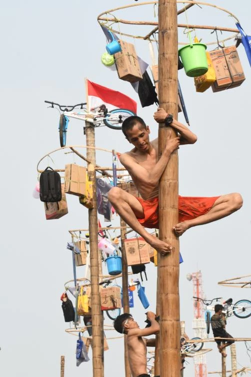 Participants take part in Panjat Pinang, a pole climbing contest, as part of festivities marking Indonesia's 72nd Independence Day on Ancol beach in Jakarta on August 17, 2017. Panjat Pinang, a tradition dating back to the Dutch colonial days, is one of the most popular traditions for celebrating Indonesia's Independence Day. / AFP / GOH Chai Hin