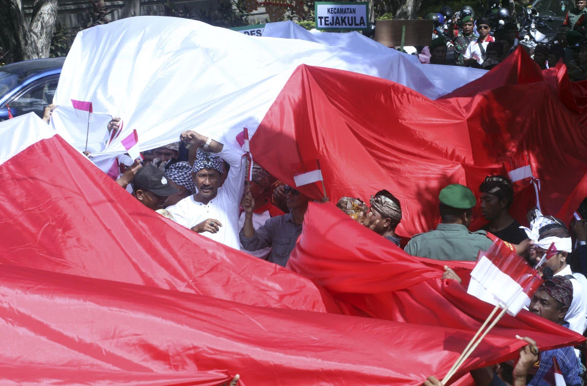 Locals display a large red and white national flag during a parade to celebrate the country's independence in Bali, Indonesia, Thursday, Aug. 17, 2017. Indonesia is marking the 72nd anniversary of its declaration of independence from Dutch colonial rule on Thursday. (AP Photo/Firdia Lisnawati)