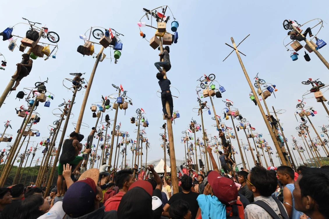 Participants take part in Panjat Pinang, a pole climbing contest, as part of festivities marking Indonesia's 72nd Independence Day on Ancol beach in Jakarta on August 17, 2017. Panjat Pinang, a tradition dating back to the Dutch colonial days, is one of the most popular traditions for celebrating Indonesia's Independence Day. / AFP / GOH Chai Hin