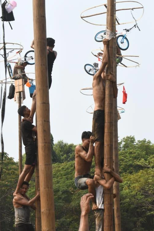 Participants take part in Panjat Pinang, a pole climbing contest, as part of festivities marking Indonesia's 72nd Independence Day on Ancol beach in Jakarta on August 17, 2017. Panjat Pinang, a tradition dating back to the Dutch colonial days, is one of the most popular traditions for celebrating Indonesia's Independence Day. / AFP / GOH Chai Hin
