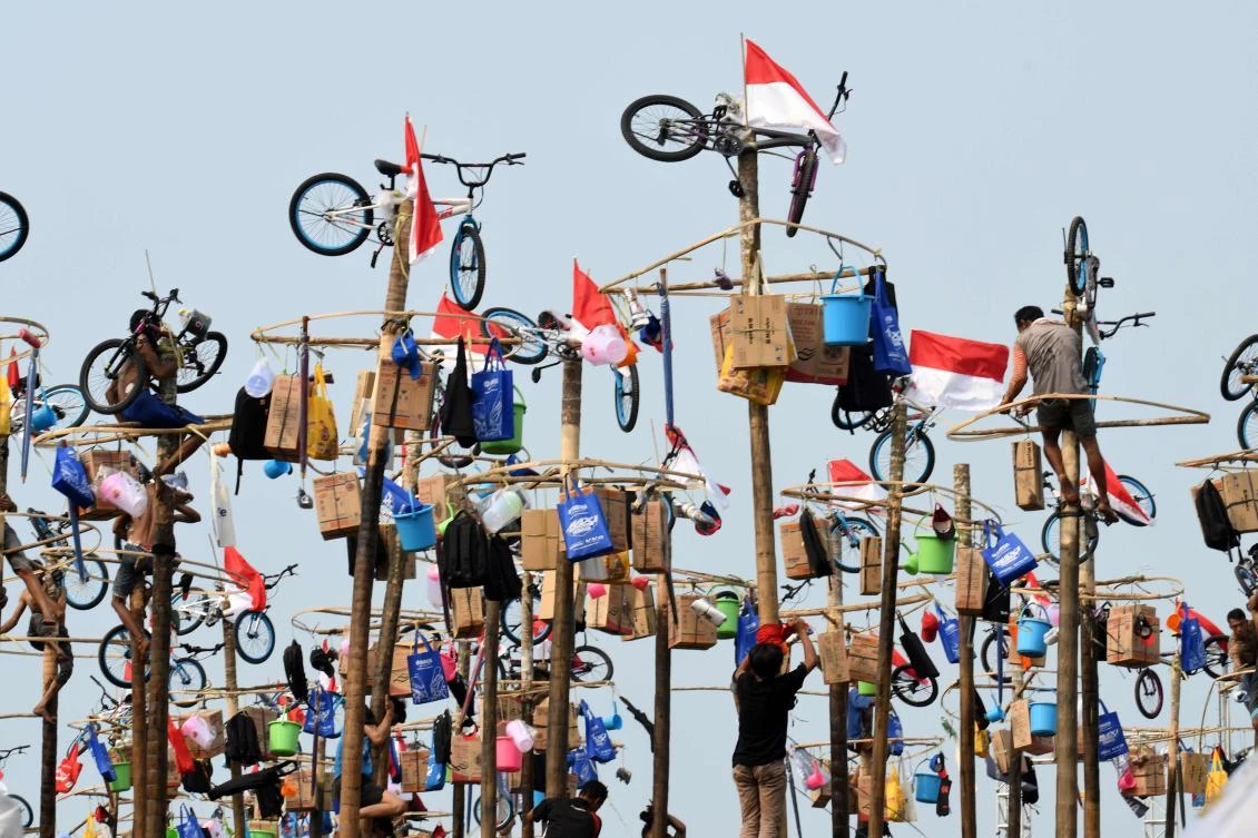 Participants take part in Panjat Pinang, a pole climbing contest, as part of festivities marking Indonesia's 72nd Independence Day on Ancol beach in Jakarta on August 17, 2017. Panjat Pinang, a tradition dating back to the Dutch colonial days, is one of the most popular traditions for celebrating Indonesia's Independence Day. / AFP / GOH Chai Hin