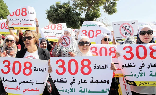 Activists protest in front Jordan’s Parliament in Amman on Tuesday. (AP)