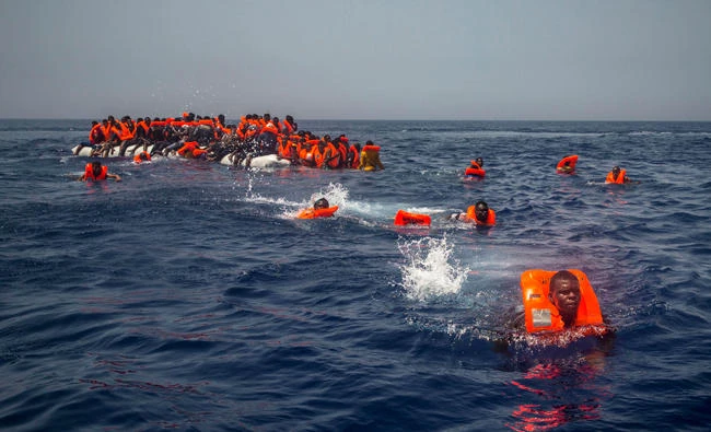 African migrants try to reach a Spanish NGO Proactiva Open Arms rescue ship after falling from a punctured rubber boat in the Mediterranean Sea, about 12 miles north of Sabratha, Libya on July 23, 2017. (AP Photo/Santi Palacios)