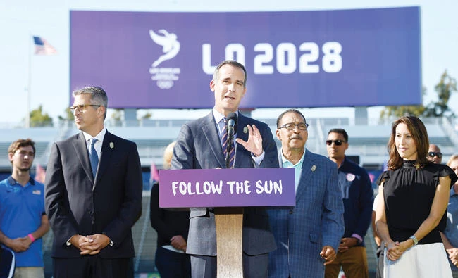 Los Angeles Mayor Eric Garcetti speaks at the podium as he announces a deal has been reached with the International Olympic Committee (IOC) to host the 2028 Summer Olympics during a news conference with LA 2024 Bid Chairman Casey Wasserman, left, City Council President Herb Wesson, and Olympian and vice chair of LA2024 Janet Evans, right, looking on at StubHub Center Tuesday in Carson, California. (AFP)