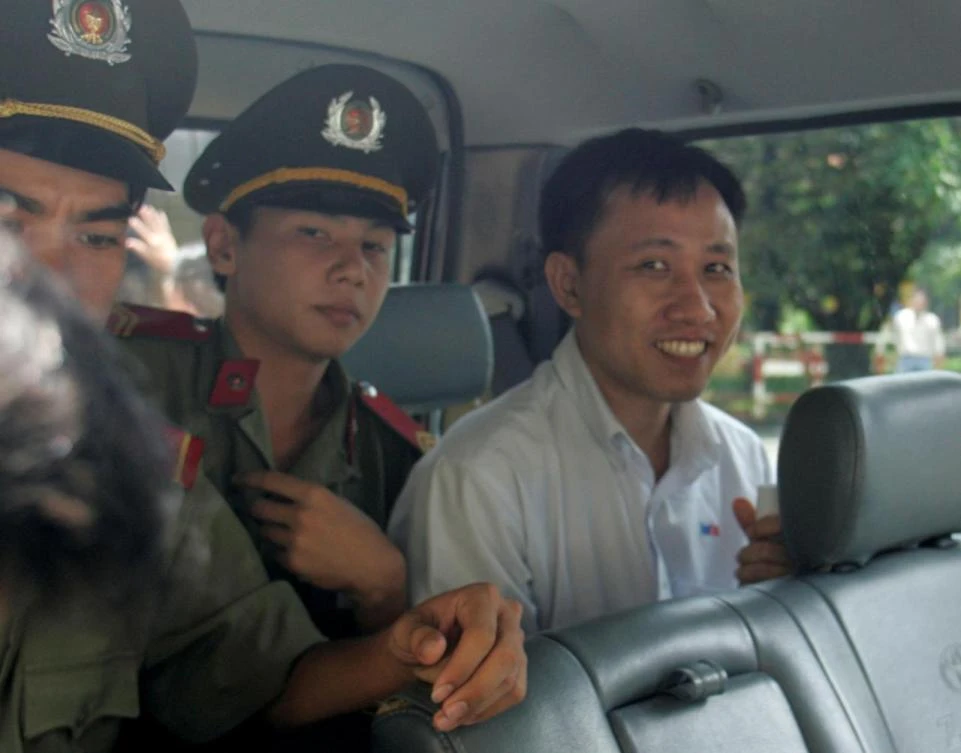 FILE - Nguyen Bac Truyen (R) sits in a police vehicle as he leaves a court in Ho Chi Minh City May 10, 2007. (REUTERS)