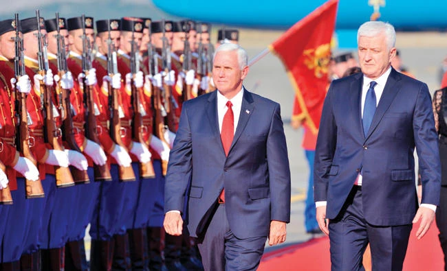 US Vice President Mike Pence, left, and Montenegro's PM Dusko Markovic review honor guards during a welcoming ceremony at Golubovci airport near Podgorica on Tuesday. (AFP)