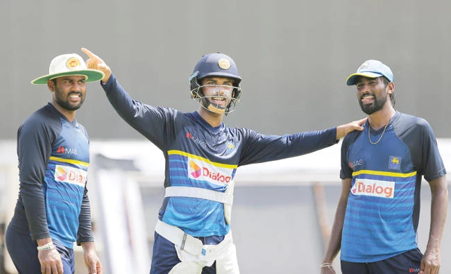 Sri Lanka's Test cricket captain Dinesh Chandimal, center, gestures as he chats with bowlers Lahiru Kumara, left, and Nuwan Pradeep ahead of their second Test cricket match with India in Colombo Wednesday. (AP)
