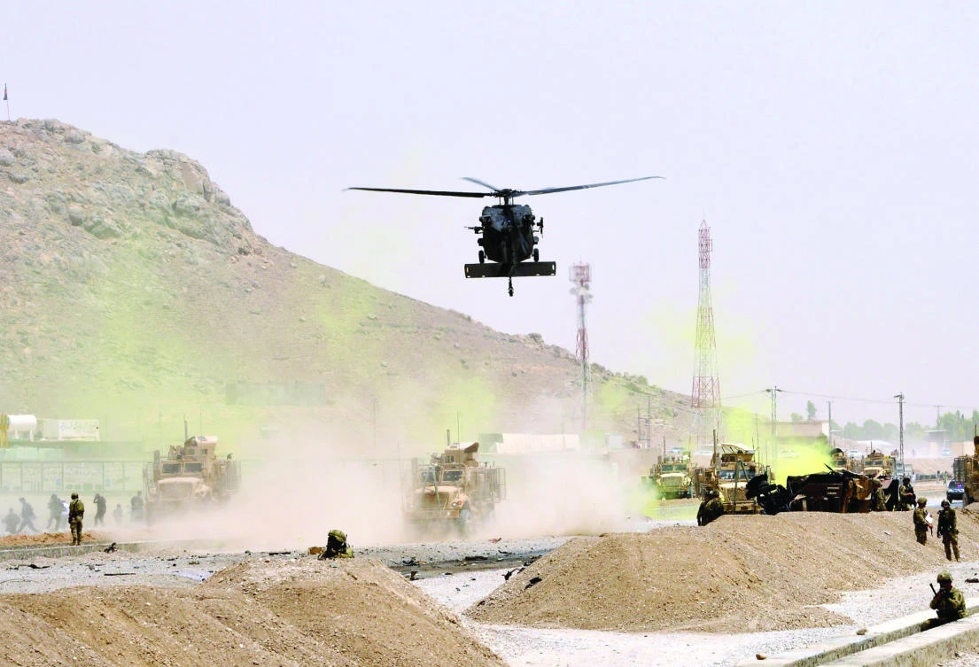 A US black hawk helicopter flies over the site of a suicide attack in Kandahar on Wednesday. (AFP)