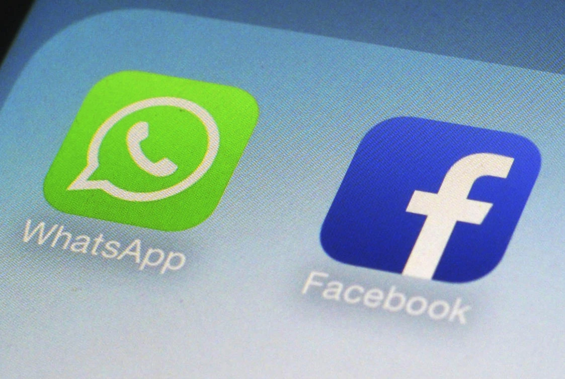 FILE - This Feb. 19, 2014, file photo, shows WhatsApp and Facebook app icons on a smartphone in New York. Facebook has squeezed just about as many ads into its main platform as it can. Any more and users might start to complain. Now, ads are moving on to Messenger, and WhatsApp may not be too far behind. (AP Photo/Patrick Sison, File)