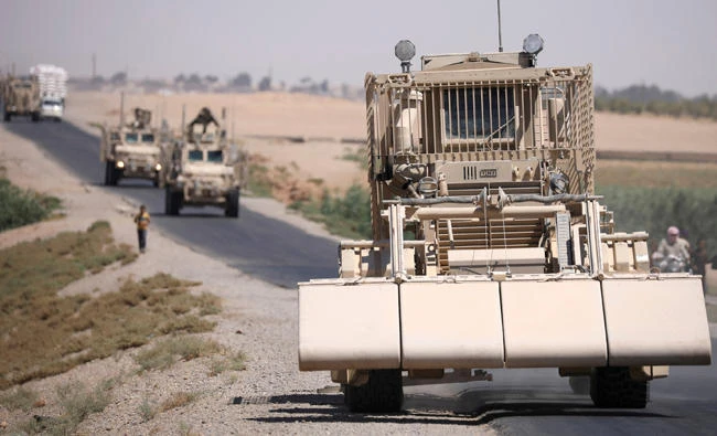 A US military demining vehicle leads a convoy on the main road in Raqqa, Syria. (Reuters)