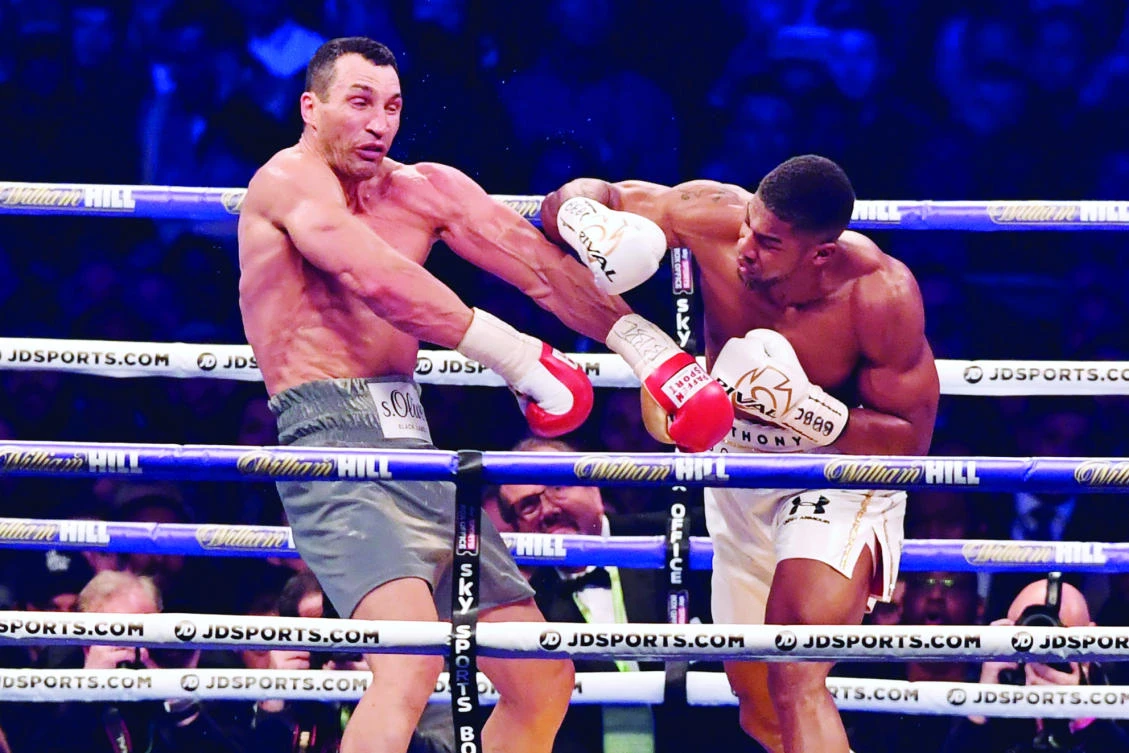 This April 30 file photo shows Britain’s Anthony Joshua, right, throwing a punch at Ukraine’s Wladimir Klitschko during the fourth round of their IBF, IBO and WBA, world heavyweight title fight at Wembley Stadium in north west London. (AFP)