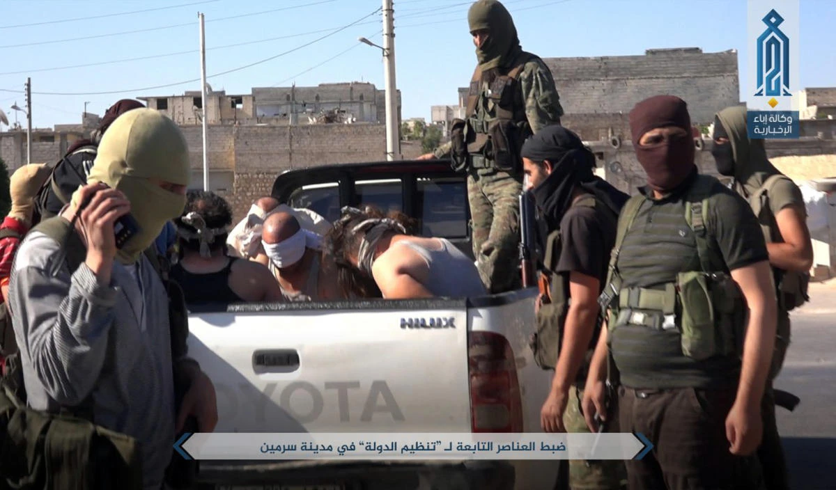 Syrian rebels and opposition activists say an Al-Qaeda-linked group is on the verge of snuffing out what remains of the 2011 Syrian uprising against President Bashar Assad in northwest Syria. Arabic reads, “Detaining members of the Daesh group in the city of Sarmin.” (AP)