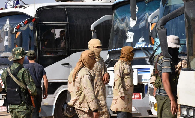 Syrian rebel fighters who evacuated from northeastern Lebanon are seen just before crossing into the rebel-held area of Al-Saan in the central Hama province on August 3, 2017. (AFP / George Ourfalian)