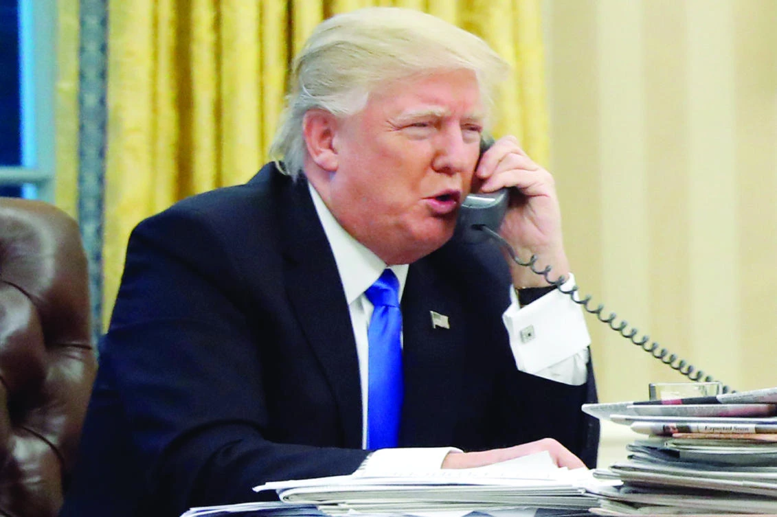 US President Donald Trump speaks on the phone with Australian Prime Minister Malcolm Turnbull in the Oval Office of the White House in Washington in this Jan. 28 photo. (AP)