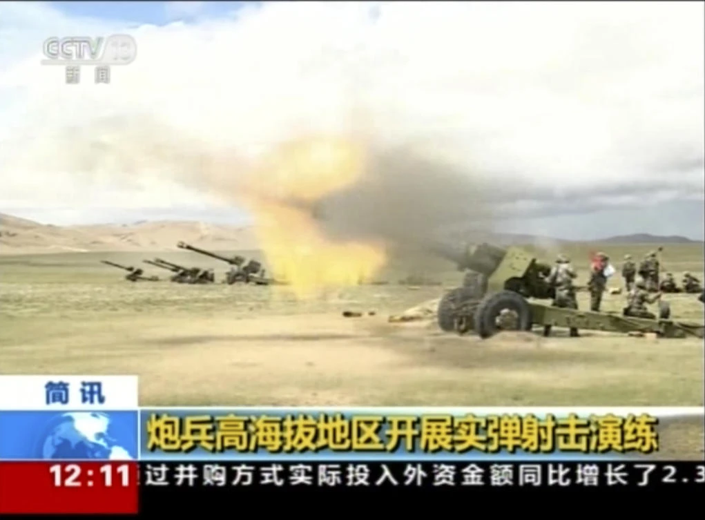 In this image taken from a recent video footage run by China's CCTV on Friday via AP Video, artillery guns fire during a live-fire drill by the Chinese army in China's Tibet Autonomous Region that border India. Beijing is intensifying its warnings to Indian troops to get out of a contested region high in the Himalayas where China, India and Bhutan meet, saying China has been restrained but "restraint has its limits." Chinese characters in yellow reads "Artillery soldiers high altitude live fire drills". (CCTV via AP Video)