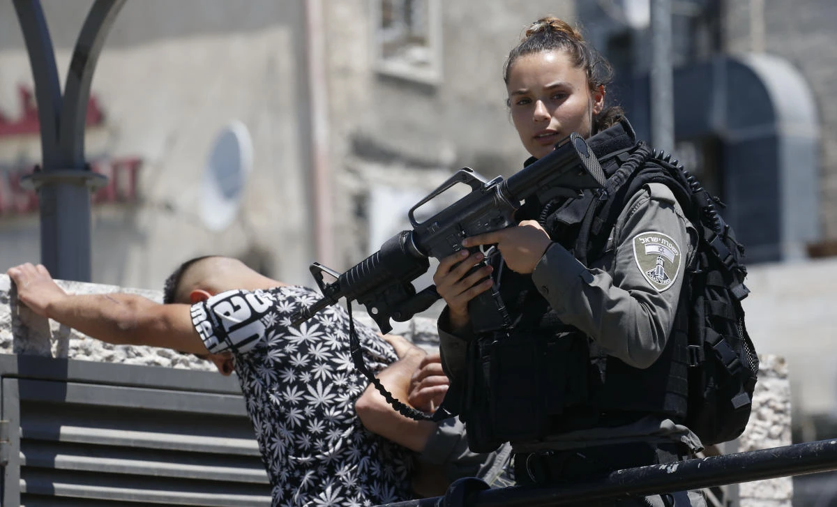 An Israeli border policewoman holds her weapon while checking the ID of Palestinians on their way to Friday noon prayer at the Al-Aqsa mosque compound in Jerusalem's old city on Friday. (AFP / HAZEM BADER)